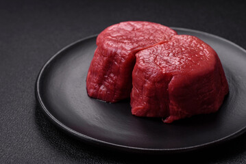 Fresh juicy raw beef medallions with salt and spices