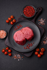 Fresh juicy raw beef medallions with salt and spices