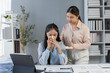 © amnaj - Manager comforts sick employee blowing nose in office, showing support and empathy. Woman looks tired, possibly has cold. Image captures human connection at work, highlighting wellness importance