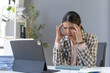 © amnaj - Businesswoman is suffering from a headache and is feeling stressed while working on a challenging project at her desk
