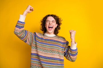 Sticker - Photo of overjoyed guy with wavy hairdo dressed ornament sweater scream win lottery raising fists up isolated on yellow color background