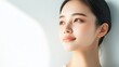 © DigitalMagicVisions - Ethereal Han Chinese Fashion Model in Modern Minimalist Attire Standing Confidently Against White Wall with Soft Light Ray Highlighting Contours of Face