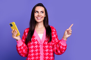 Wall Mural - Photo of cheerful dreamy lady dressed pink cardigan typing modern device pointing empty space isolated violet color background