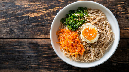 Indulge in a mouthwatering bowl of soba noodles with a perfectly cooked egg, spicy kimchi, fresh green onions, and a savory sauce garnished with sesame seeds