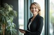 © Ekkarat_Studio - Confident Businesswoman Holding Tablet Near Window