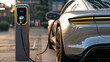 © top images - A silver car is being charged at a charging station
