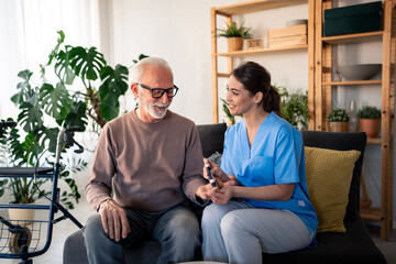 a cheerful caucasian nurse in blue scrubs provides professional in-home care for a senior male patie