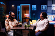 © DC Studio - African podcasters having joyful discussion in home studio, exchanging various topics with online listeners. Show presenter with notebook is interviewing female socialite, having positive interactions