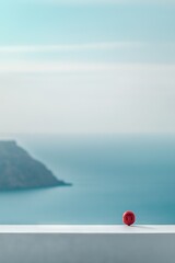 Sticker -   A red object rests on a white ledge beside a body of water and a mountain in the background