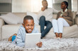 © Flashizzle/peopleimages.com - Boy, relax and floor with tablet at house for streaming, education games and watch videos of learning. Child, black family and digital with online app, multimedia film and entertainment subscription
