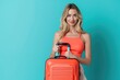 © kitipol - Elegant lady holding luggage, solid color background