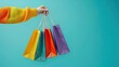 © Dilruba - Superb Female hand holding many colorful shopping bags on blue background, template