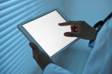 Wall Mural - Doctor using tablet in hospital at night, closeup