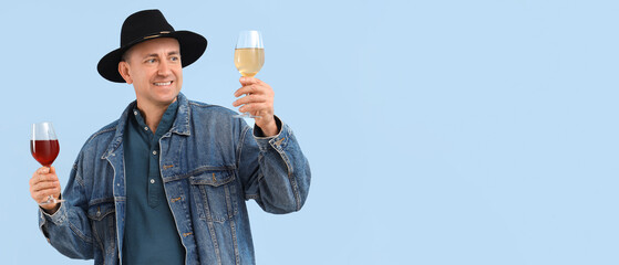 Poster - Mature man with glasses of wine on blue background