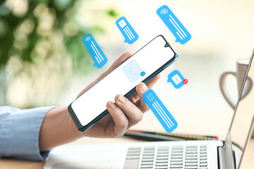 Wall Mural - Woman holding modern mobile phone at table, closeup