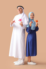 Canvas Print - Beautiful Muslim couple with red ribbons and condoms on brown background. AID awareness concept