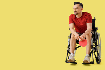 Sticker - Sporty young man in wheelchair with ping pong racket and ball on yellow background