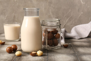 Wall Mural - Glass and bottle of fresh macadamia milk on grey tile table