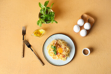 Wall Mural - Plate with tasty pasta carbonara and ingredients on beige background