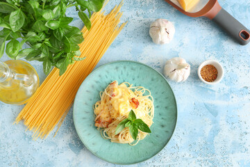 Wall Mural - Plate with tasty pasta carbonara and ingredients on blue grunge background