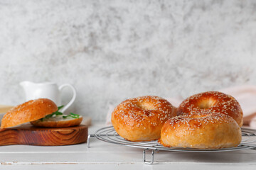 Wall Mural - Stand and board with tasty bagels on white wooden table