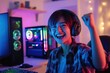 © LimeSky - Young Asian transgender gamer celebrates victory with raised fist while gaming on PC in bedroom