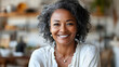 © Siasart Stock - A smiling woman with curly hair in a cozy indoor setting.