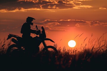 Wall Mural - Motorcyclist on off road bike at sunset in a field silhouette