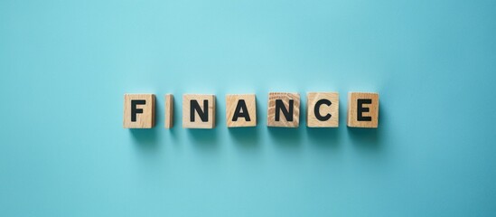 wooden cube blocks make the word finance on a blue background