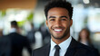 © Siasart Stock - A handsome young businessman smiles confidently at the camera while wearing a suit and tie.