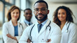 © Siasart Stock - Confident African American doctor with colleagues in the background.