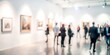 © Mari - Blurred background of an art exhibition opening with guests and artworks.