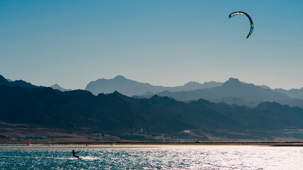 Poster - kitesurfer rides in the Red Sea on the background of a rocky coast in Egypt Dahab South Sinai