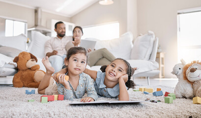 Relax, parents and children in home with toys, teddy bear and coloring book for development activity. Happy, portrait and girls on floor to play, learn and bonding together with mom and dad on sofa.