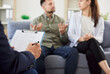 © Studio Romantic - Young married upset couple man and woman sitting on sofa in counselor's office during family therapy session with male psychologist trying to find solution. Effective marital therapy concept.