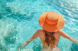 © João Macedo - Woman with orange hat relaxing in a refreshing swimming pool during summer