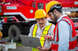 © SKW - Two men in safety gear are looking at a piece of machinery. They are wearing reflective vests and hard hats