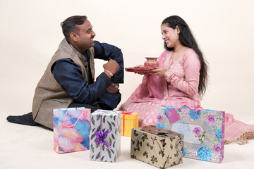 Sister tying Rakhi on her brother's wrist as they celebrate Raksha Bandhan, sharing moments of love and fun on this special day.