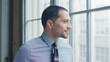 © Monkey Business - Head And Shoulders Portrait Of Smiling Young Businessman Looking Out Of Window In Office