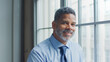 © Monkey Business - Head And Shoulders Portrait Of Smiling Mature Businessman Standing By Window In Office