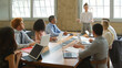 © Monkey Business - Young Businesswoman Giving Presentation To Multi-Cultural Team Sitting Around Table In Modern Office