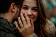 © Ostrich - Close up photo of a smiling woman hugging a man and showing off her engagement ring. Engaged couple in love.