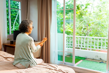 asian senior mature woman sit on the bed suffering from finger wrist hand pain. unhappy elderly feel