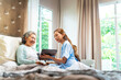© CandyRetriever  - Asian woman doctor examine senior patient using blood pressure gauge on the bed. Professional nurse visit and take care elderly woman at home. Home medical therapy and health care insurance concept.