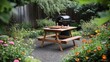 © bcendet - Picnic table with food and grill in a backyard garden setting.