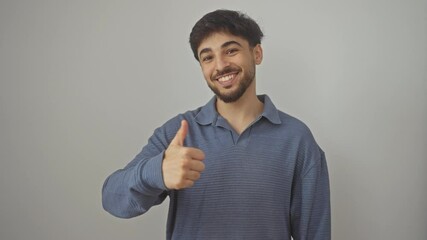 Wall Mural - Young, happy, smiling arab man giving thumb up sign, positive approval, symbol of success, standing over an isolated white background, excellent gesture