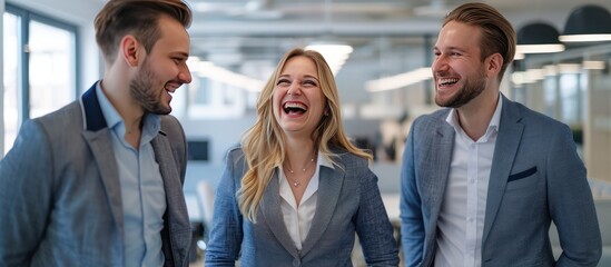 Three businesspeople, blonde woman laughing, two men in grey and blue blazers, bright office, corporate teamwork concept.