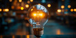 © pabscal - A light bulb glowing in an interior room with lights, representing creativity and inspiration, with plenty of copy space around it.