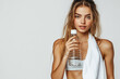 © lashkhidzetim - woman is holding a water bottle a. She has a bright smile on her face. Fitness concept.