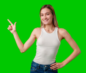 Sticker - Young Woman Wearing White Tank Top Points to the Right With a Smile on Green Screen